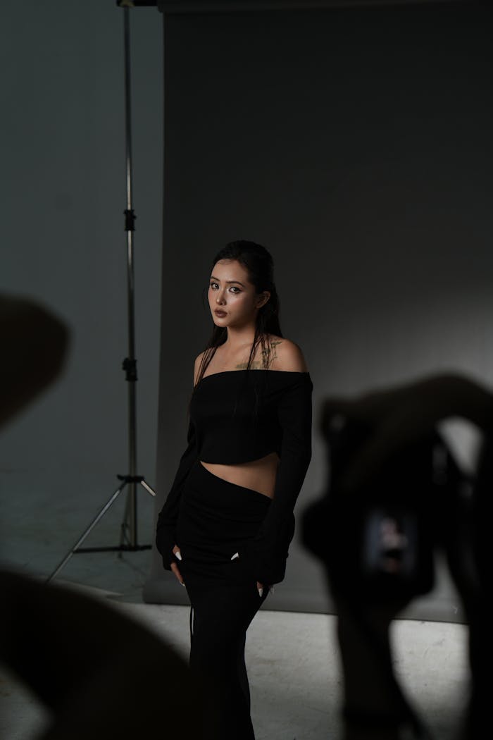 Elegant studio portrait featuring a woman in stylish black attire with professional lighting setup.